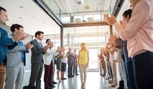 Image of a woman being congratulated by others.