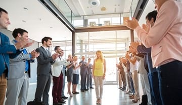 Image of a woman being applauded by others.