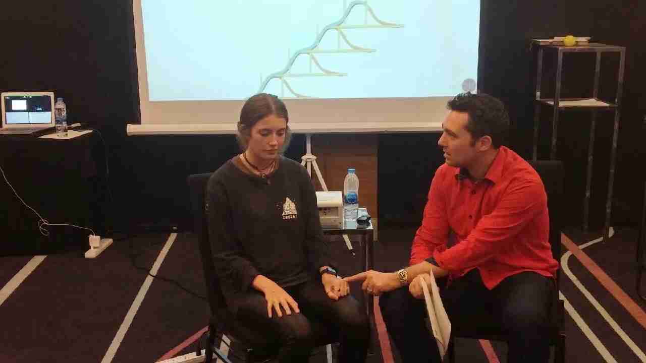 Sebastian Leblond sitting with a student during a training course and working one on one to learn a technique.