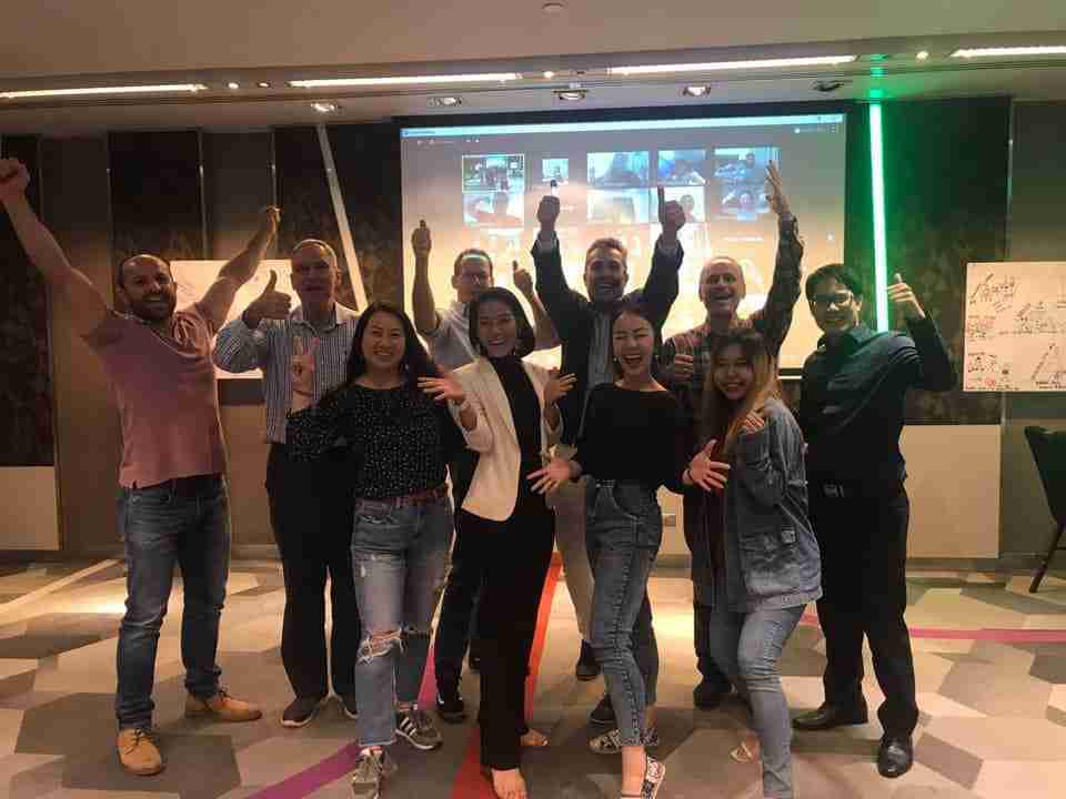 A group of NLP Top Coach trainees smiling and enjoying the benefits of neuro-linguistic programming during a training seminar.